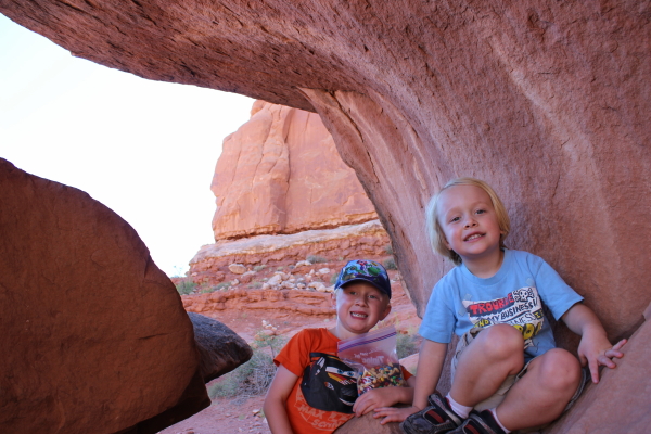 Toren and Ethan climbing on rocks in Arches.